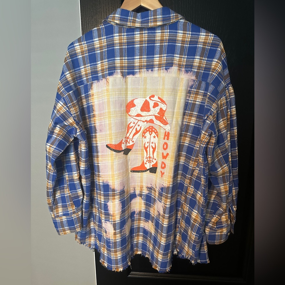 New without tags, flannel button down with cowboy boots on back.